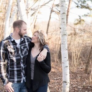 A man and woman standing in the woods