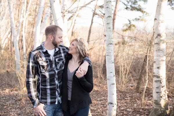 A man and woman standing in the woods